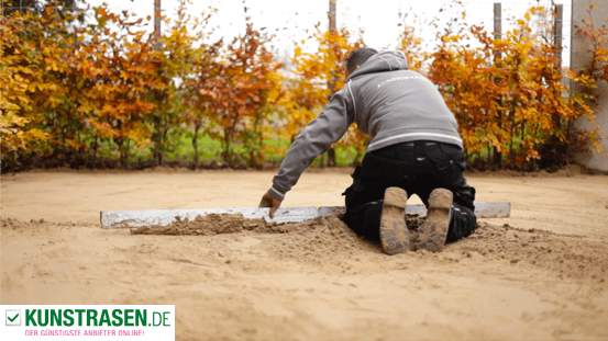 Mann egalisiert den Sand